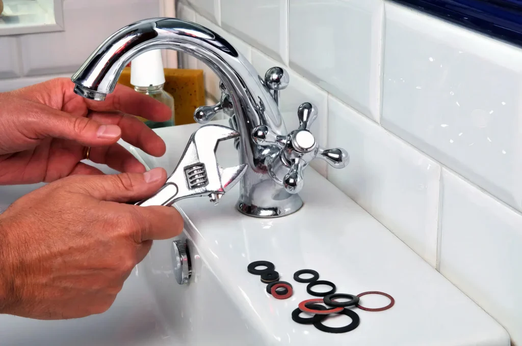 Plumber performing maintenance on a bathroom faucet in Carlsbad