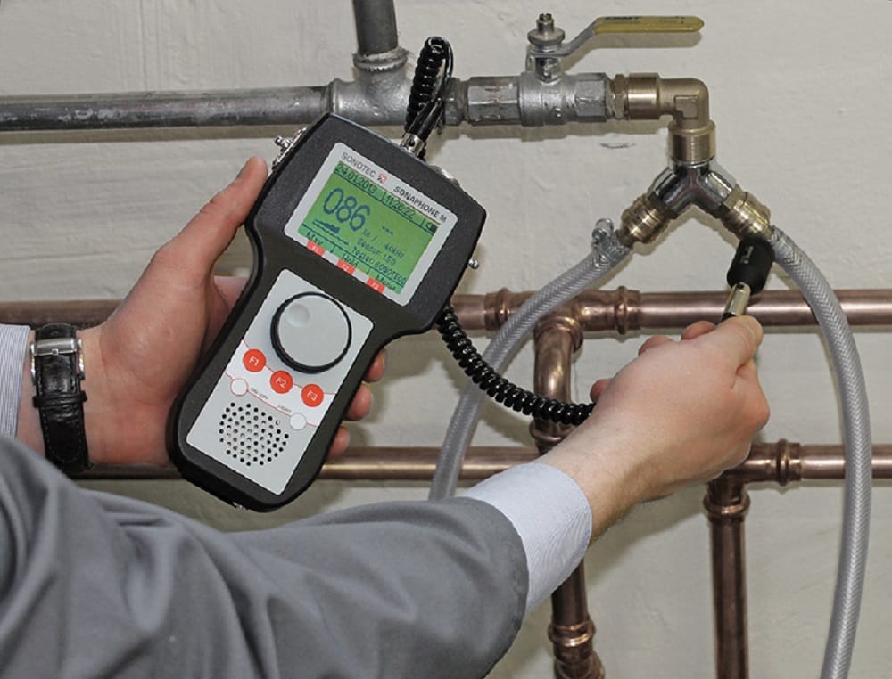 Plumber testing pipes with electronic leak detection equipment in Carlsbad