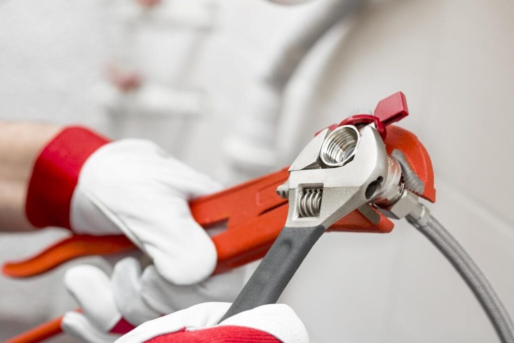Plumber holding pipe wrenches for an emergency repair in Carlsbad