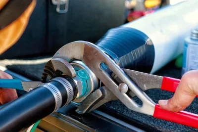 Technician tightening an industrial pipe connection in Carlsbad