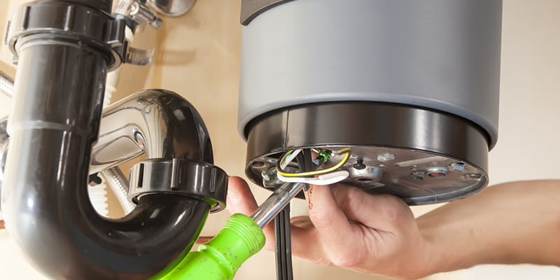 Technician repairing the heating element of a water heater in Carlsbad