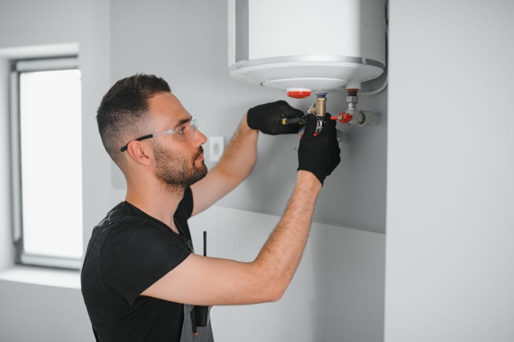 Technician performing water heater maintenance in Carlsbad