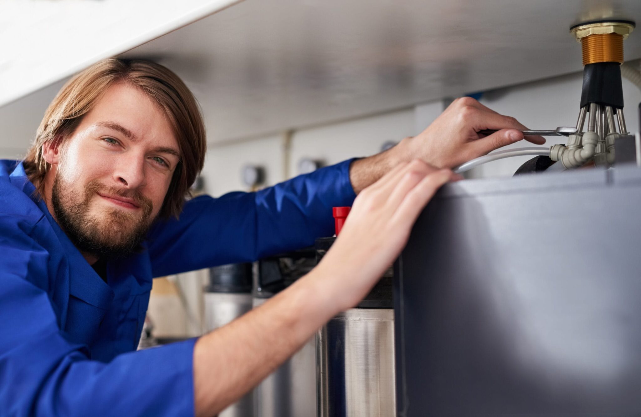 Technician servicing a residential water heater tank in Carlsbad