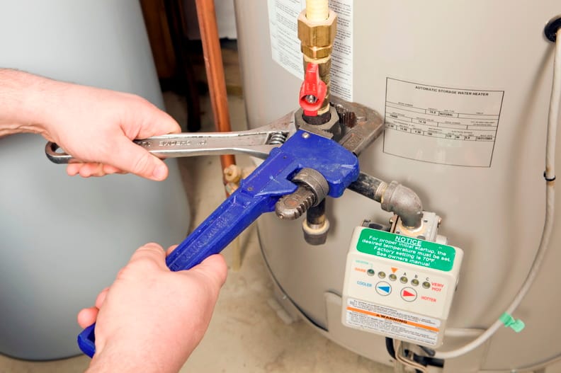 Plumber repairing a water heater valve in Carlsbad